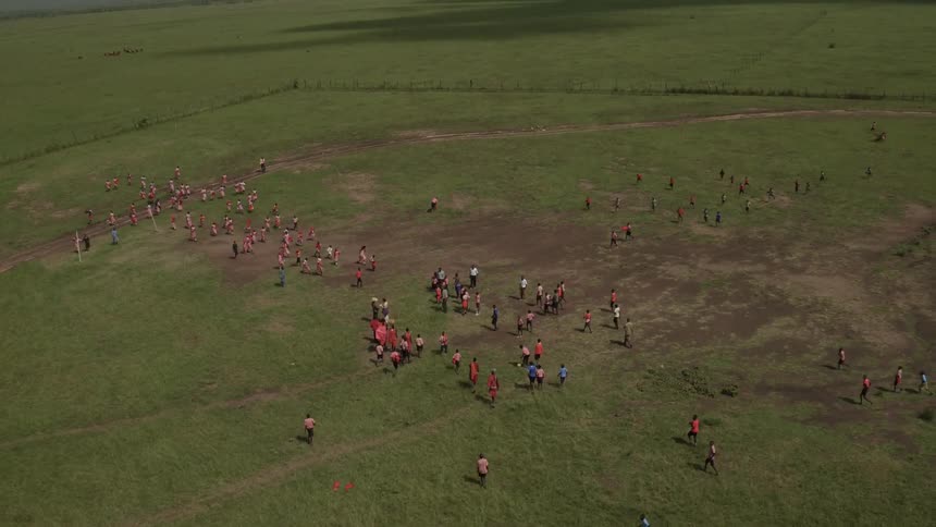 Group of people assemble on a grassy field