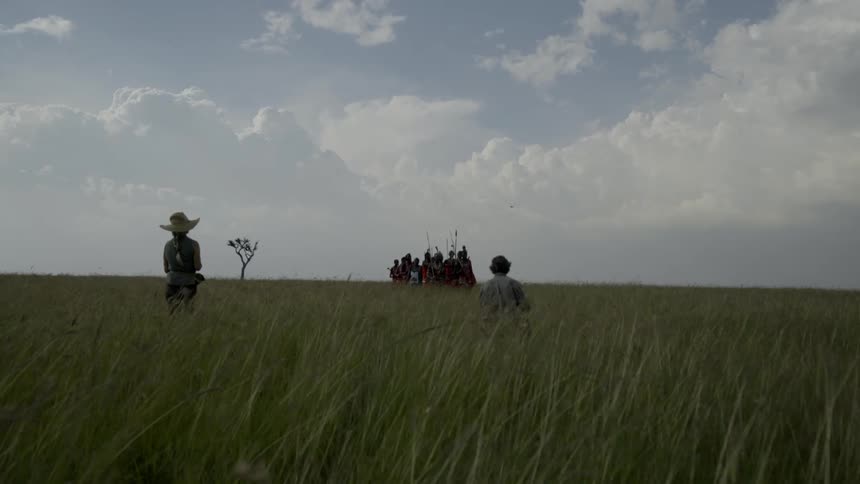 Two photographers are taking photos of a group of african tribesmen during the day