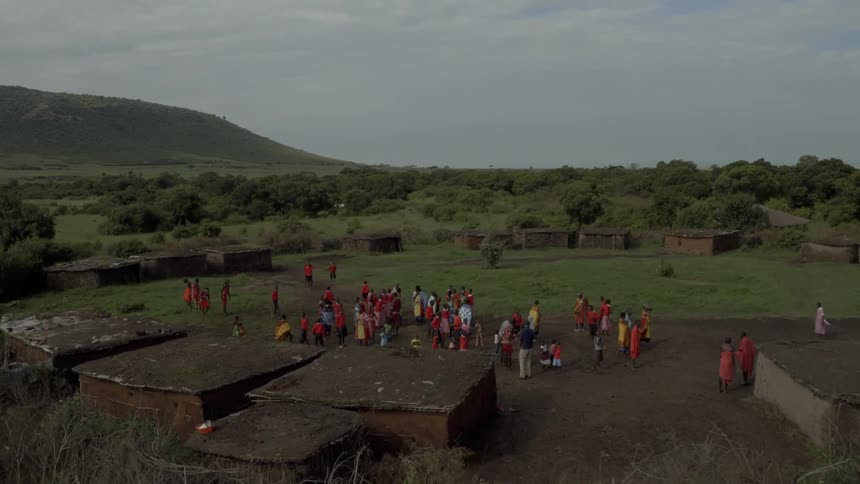 Maasai people gather outside their village displaying their native costumes