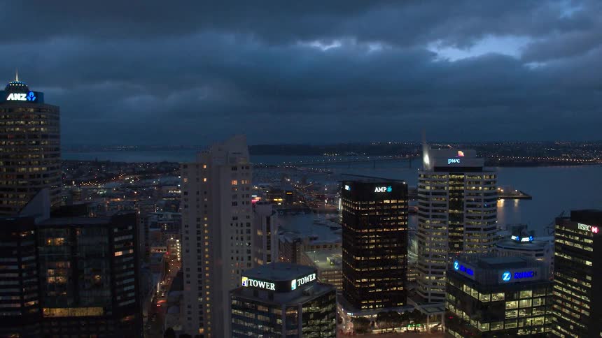 Clouds move in from the ocean toward a city at night
