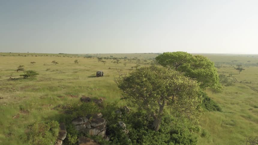 A jeep is driving off road during the day in Africa