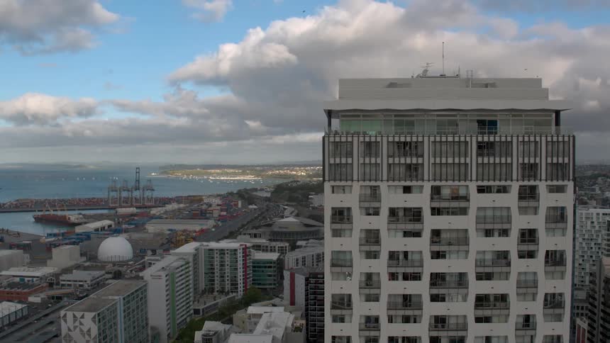 A bird flies above tall city buildings