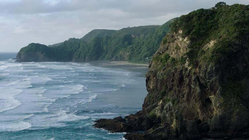 High rock formations around a beach area on a cloudy day