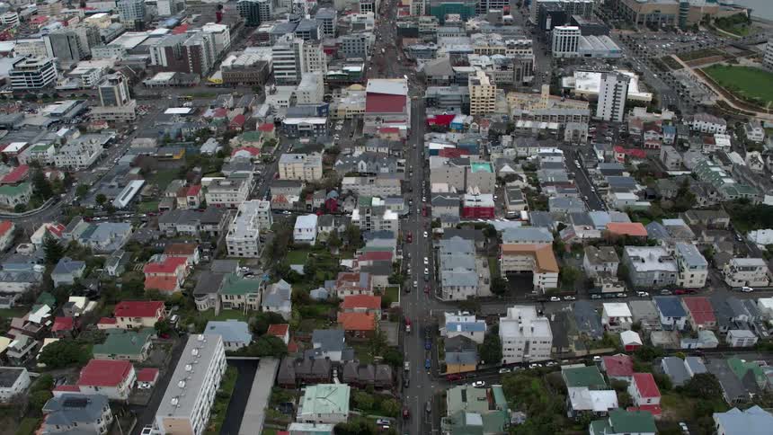 The cars drive down the main road of the city below
