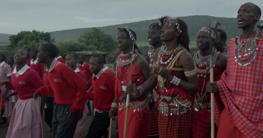 Maasai sing and chant while holding on to sticks