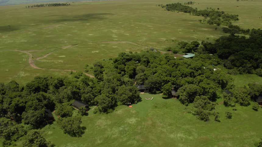 A copse of trees surrounds a compound in a remote area