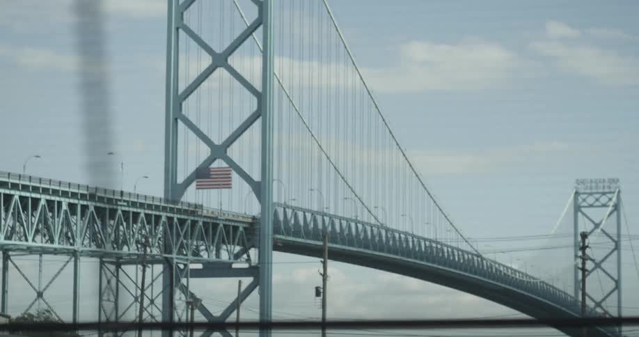 An american flag is displayed on a large bridge