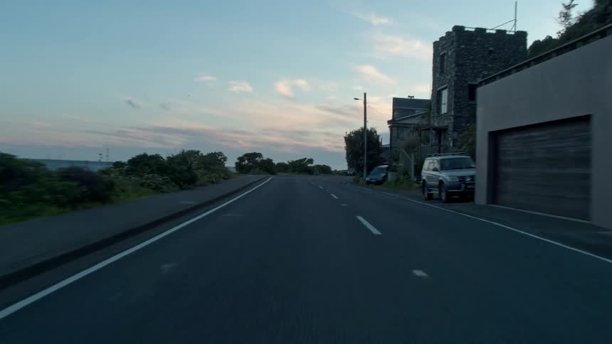 Vehicles travel along a beach side road