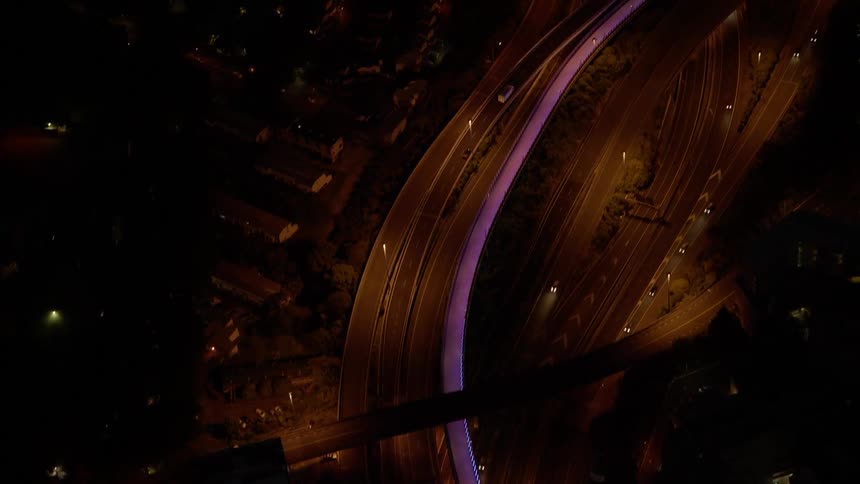 Vehicles travel on a city road at night