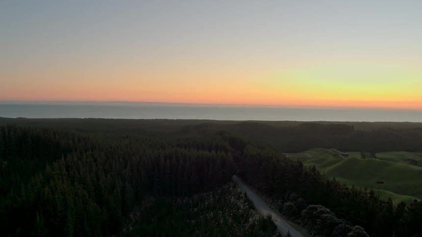 The sun sets above the water on the shore