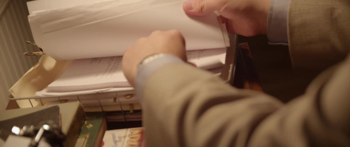 A person sorts through papers on a desk
