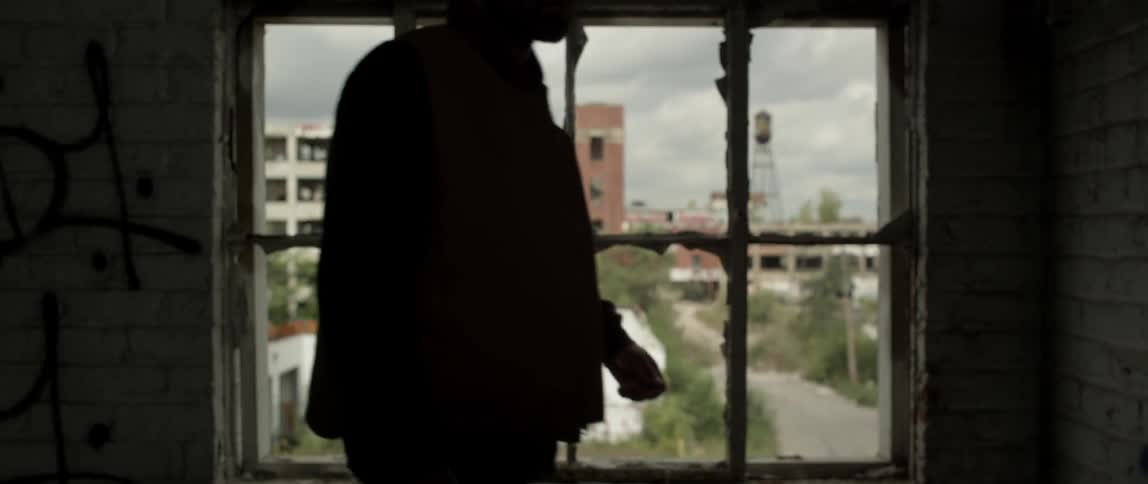 A man walks past the window of the dark building