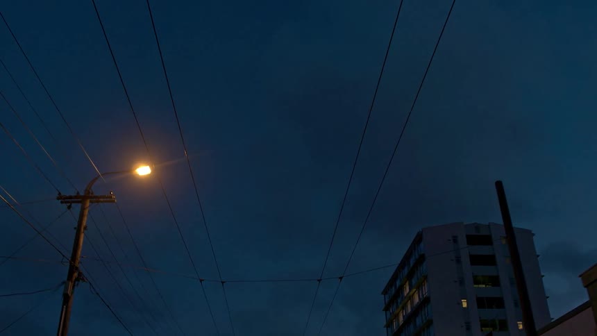 Power lines hang above the road at night