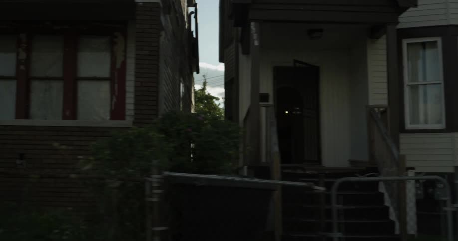 A row of houses are being viewed from a passing car