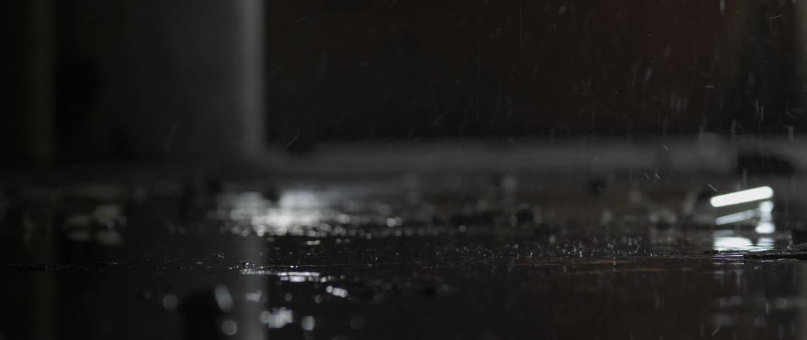Water drips onto a concrete surface inside a building