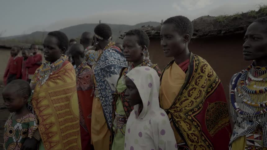Maasai stand outside their village displaying their native costumes