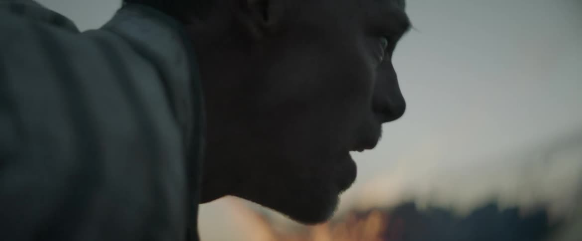 A man looks disheveled by a fire
