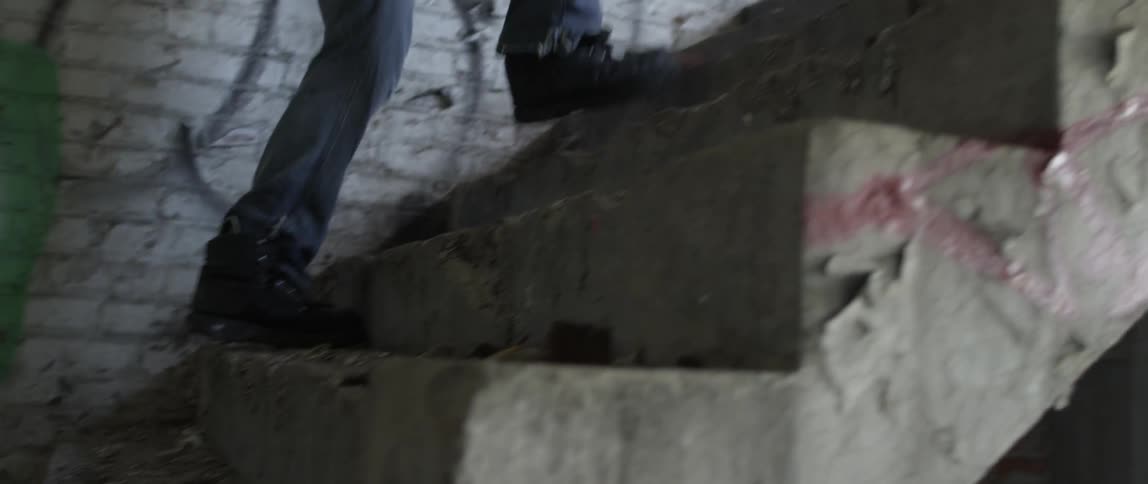 Person walks up stairs next to walls covered in graffiti