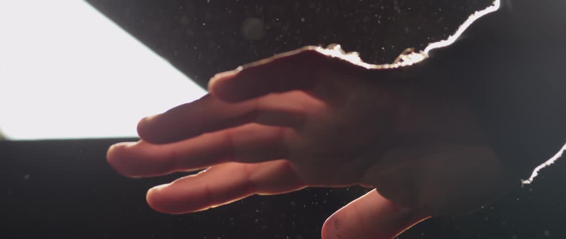 Hand being held over something outdoors and turning slightly back and forth
