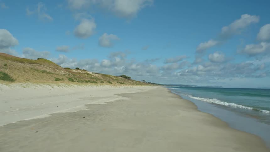 The waves slowly crash against the shoreline