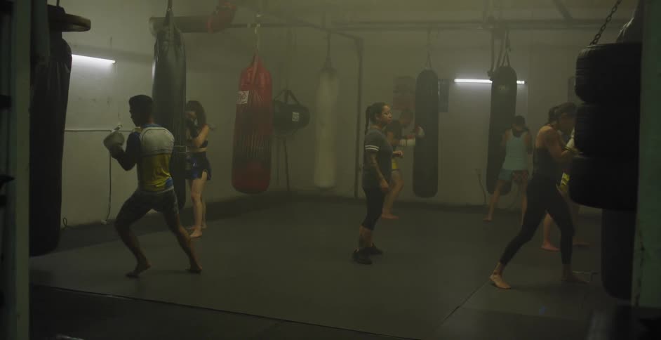 Women practice punches in a gym