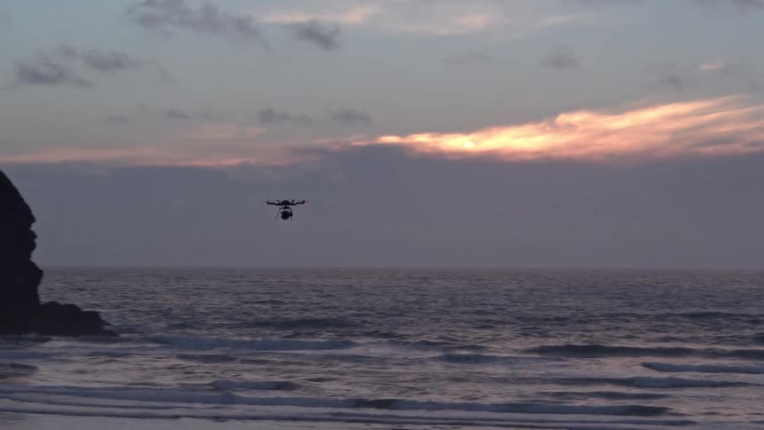 A drone flies over the water