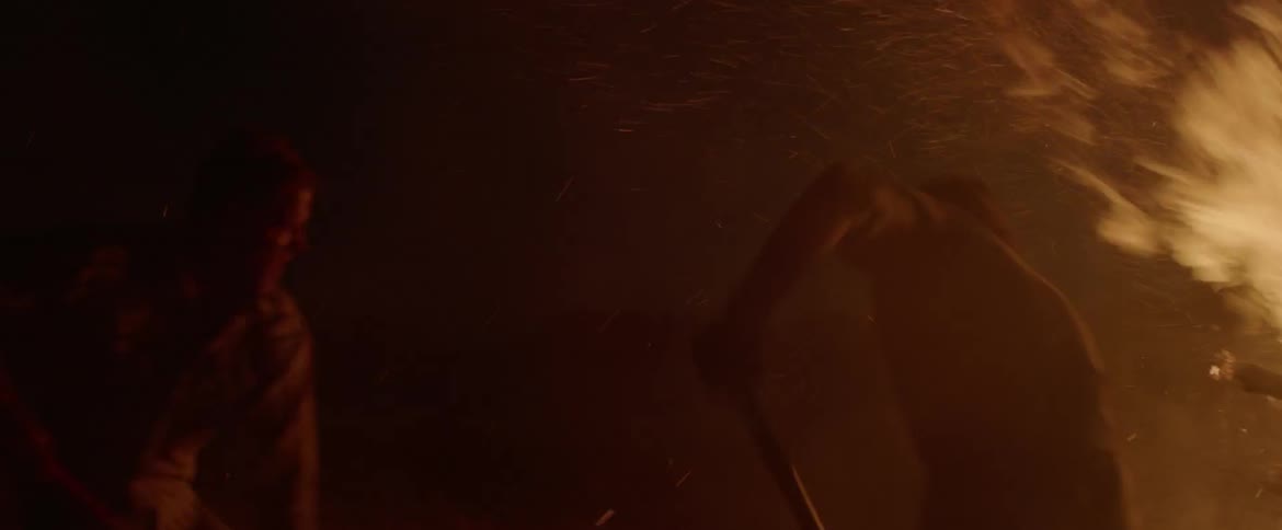 A man attempts to extinguish a fire
