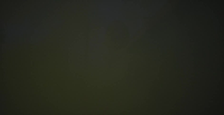 Man standing outside surrounded by smoke at night