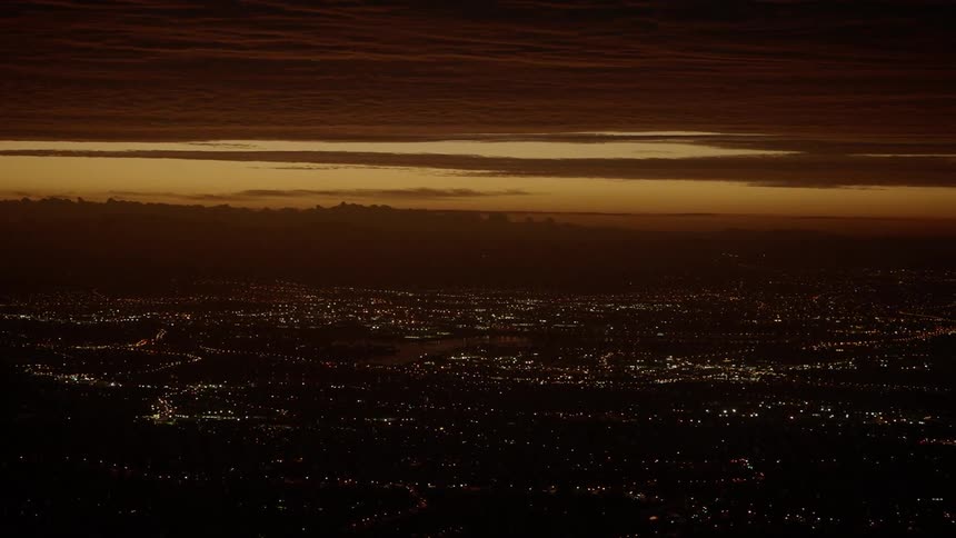 City lights illuminate below cloudy skies