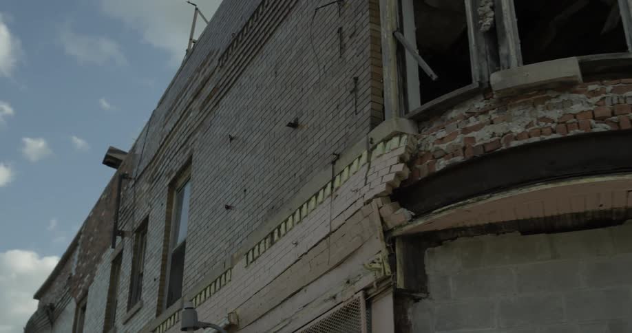 The  facade of an old two-story building is falling apart