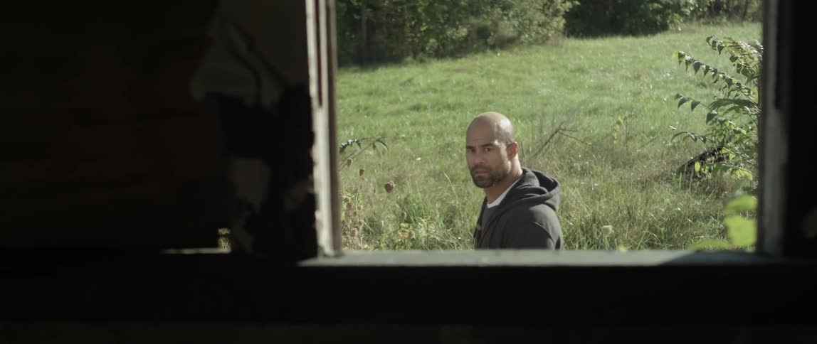 A man walking outside looks at the building he is passing