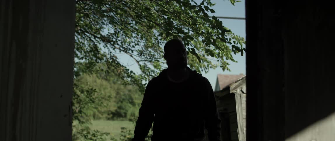 A man walks through the yard on a sunny day