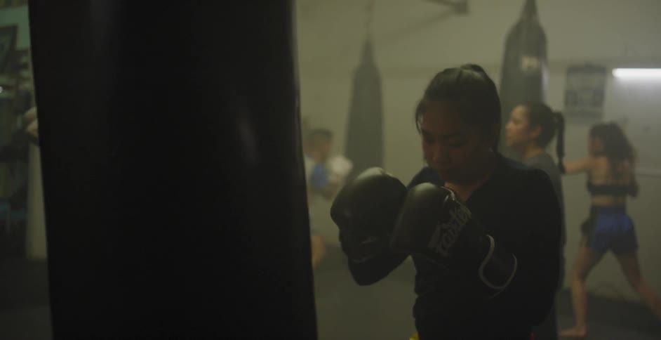 Women train boxing with heavy bags