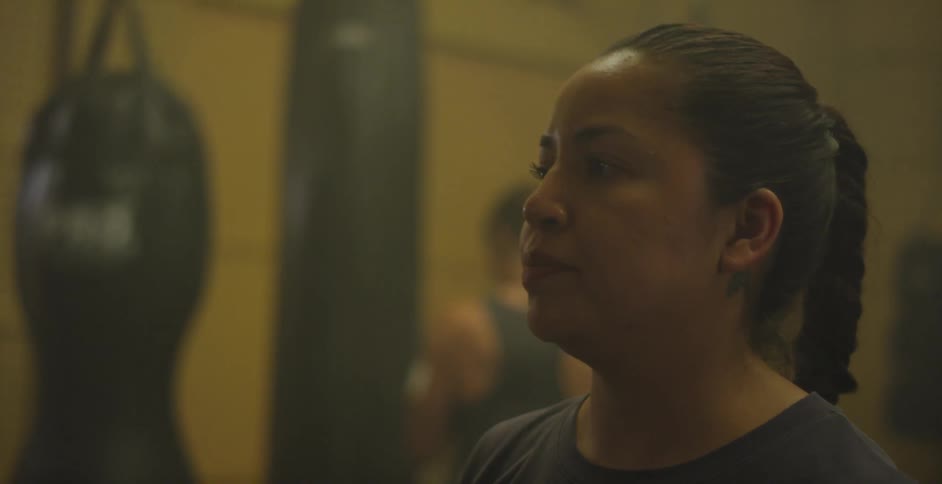 Women practice punches in a gym