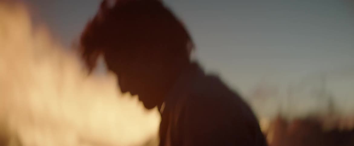 A man is frantically shoveling dirt onto a fire