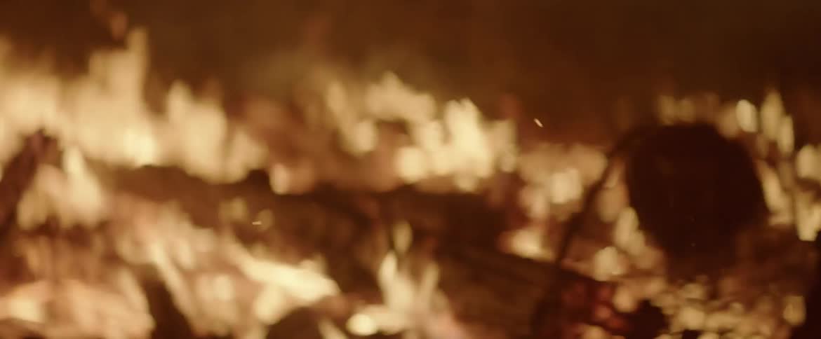The campfire is burning the many branches inside at night