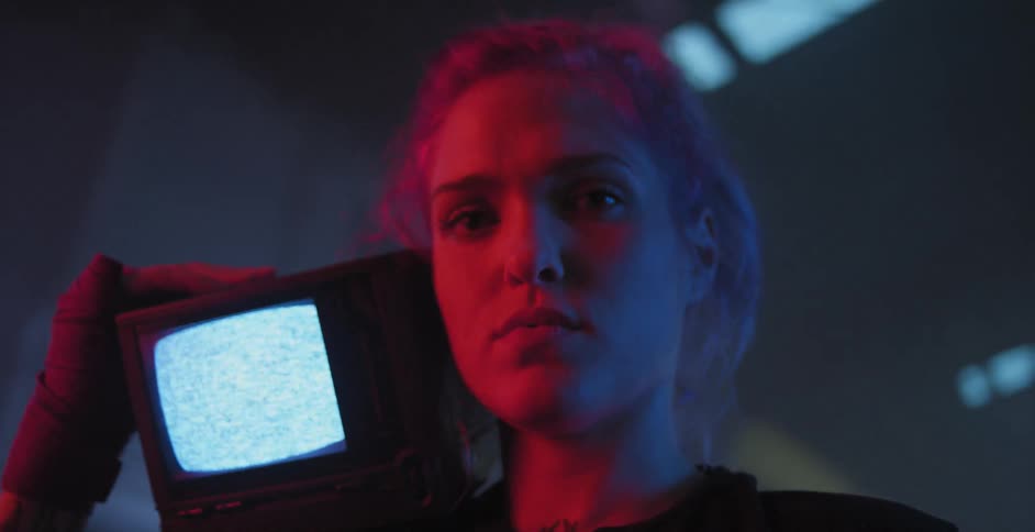 Woman holds a small television displaying static