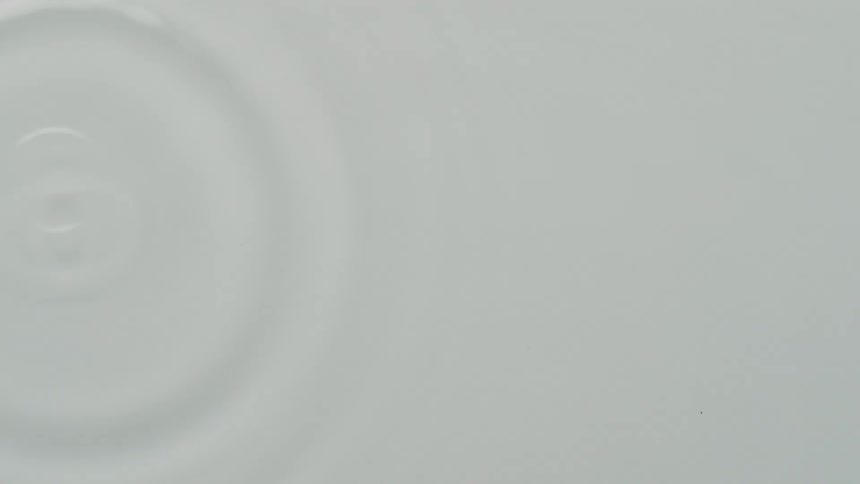 White liquid ripples as droplets fall
