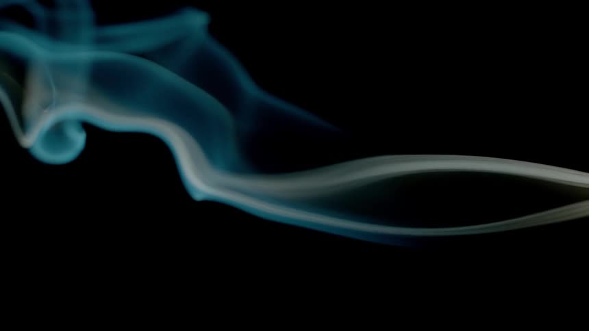 Blue smoke is filmed close up with a black background
