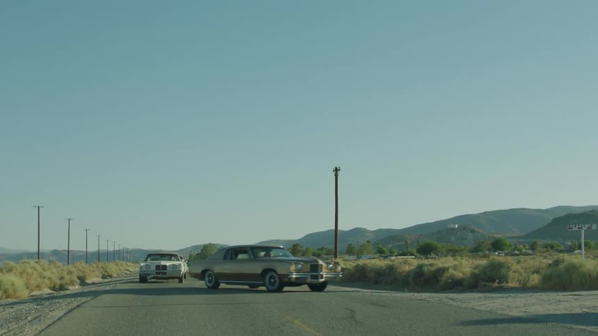 A line of cars turn down a street