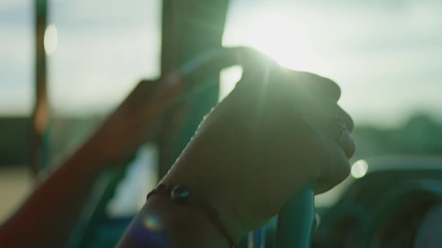 A person is driving a car in the sunshine