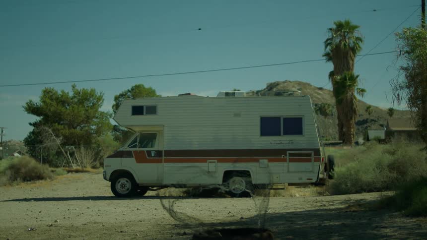 A recreational vehicle is parked in the log on a sunny day