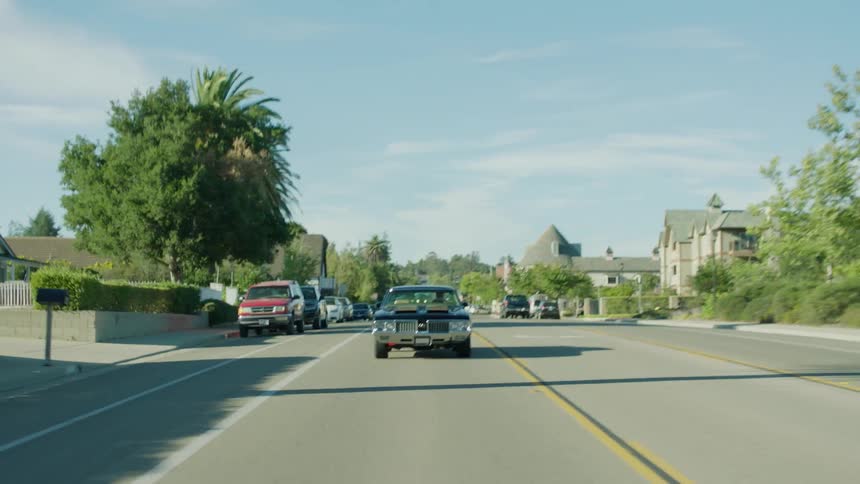 A car is driving through a neighborhood