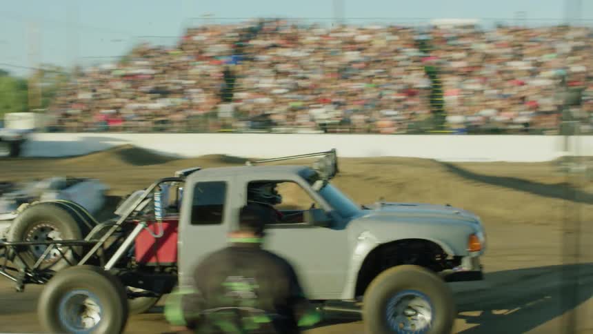 Truck jumps over dirt mound at demolition derby