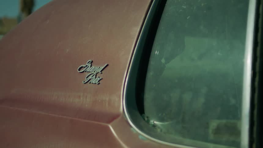 A orange classic car is filmed close up of the back window