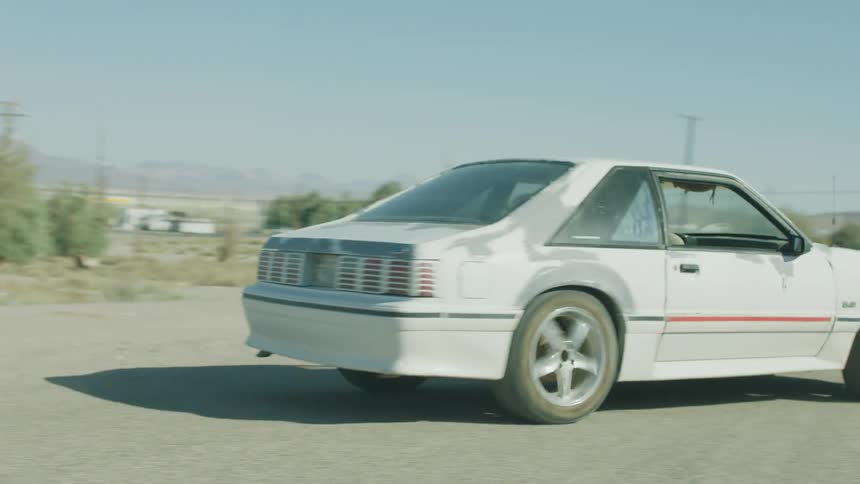 A ford mustang backs up and speeds off