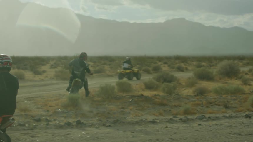 People ride off road vehicles on a dirt and gravel road