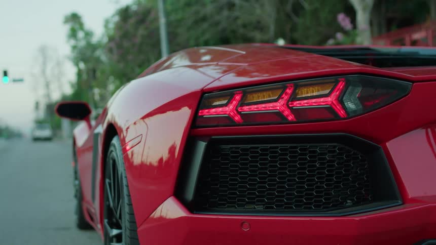 A red sports car sits parked on the side of the road