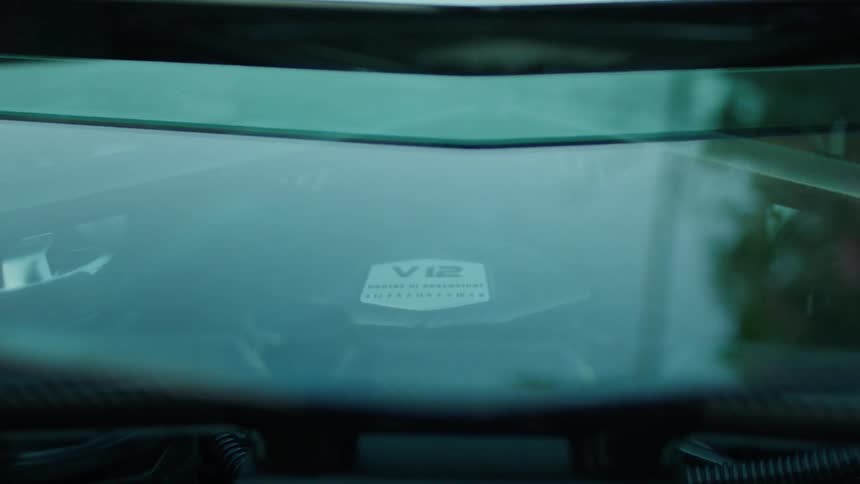 A car's engine is filmed through a glass window