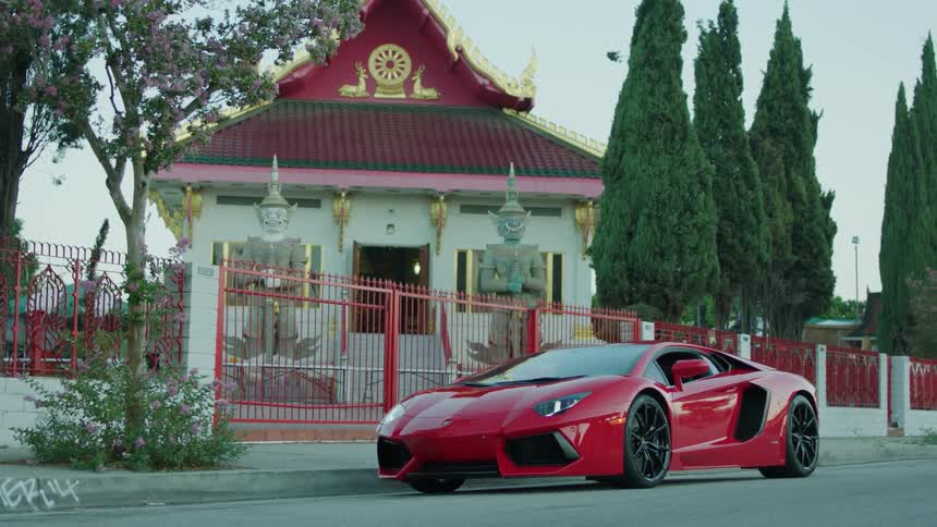 An expensive sports car is parked outside of a church